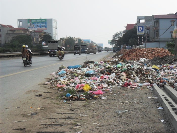 Bãi rác thải tự phát bốc mùi hôi thối khiến người đi đường phải bịt mũi trên quốc lộ 5, thuộc địa phận xã Trưng Trắc, huyện Văn Lâm (Hưng Yên).